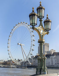 Ferris wheel in city against clear sky