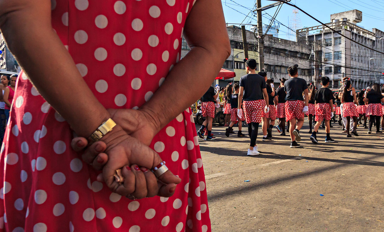 real people, large group of people, women, day, midsection, crowd, lifestyles, city, holding, leisure activity, men, group of people, architecture, casual clothing, human hand, human body part, hand, standing, built structure, polka dot, outdoors, finger