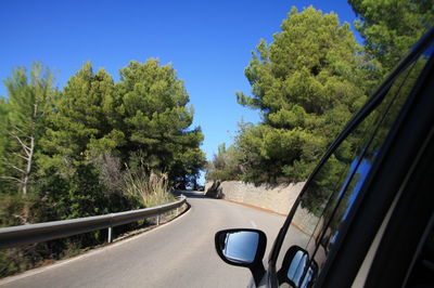 Car moving on road against clear sky