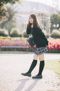 Full length of young woman standing outdoors