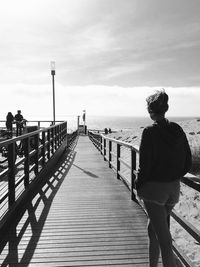 Rear view of teenage girl standing on pier