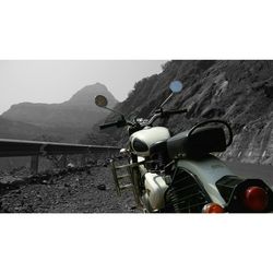 Close-up of motorcycle on mountain against clear sky