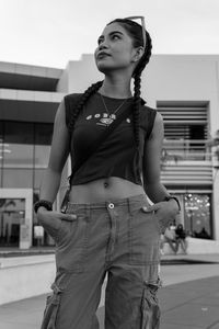 Portrait of young woman standing in city