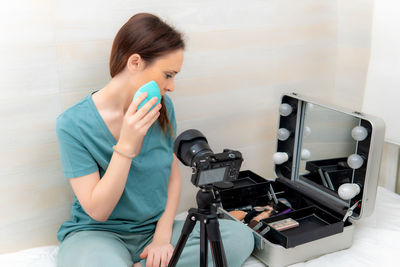 Full length of woman sitting at home