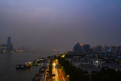 High angle view of illuminated buildings against sky at dusk