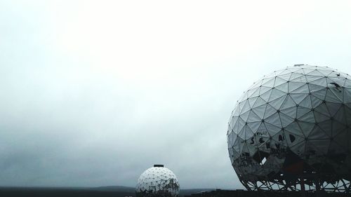 Close-up of crystal ball against sky