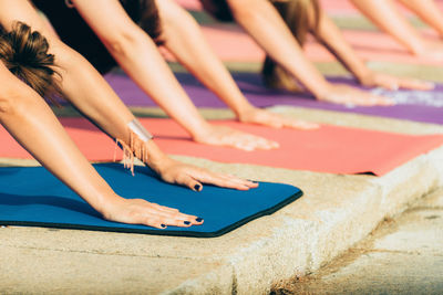 Cropped hands of women practicing yoga outdoors