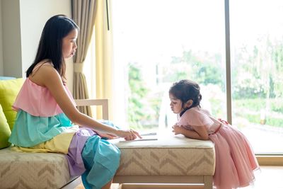 Mother assisting daughter in homework at home