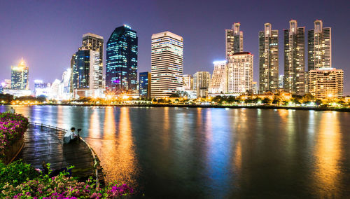 Illuminated cityscape against sky at night