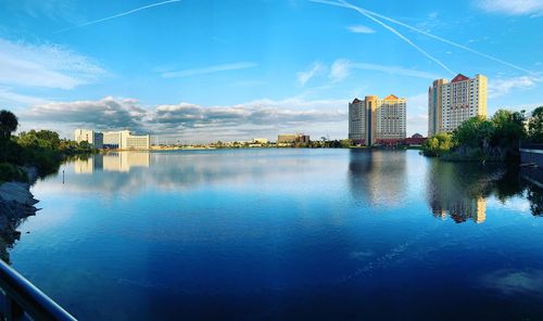 Scenic view of lake by buildings against sky