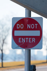 Close-up of road sign against sky