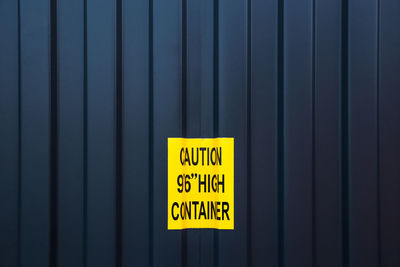 Close-up of yellow sign on cargo container