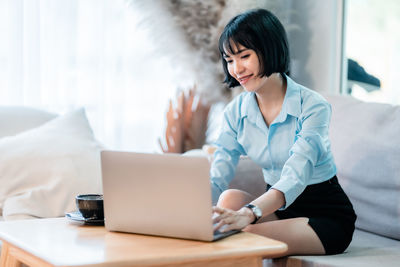 Young woman using laptop at home
