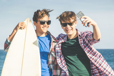 Teenagers friends using smartphone. smiling teens taking selfie. boys watching video on mobile phone