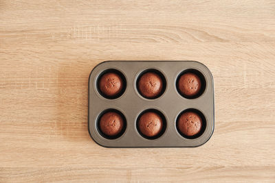 Golden cupcakes in shape on wooden table