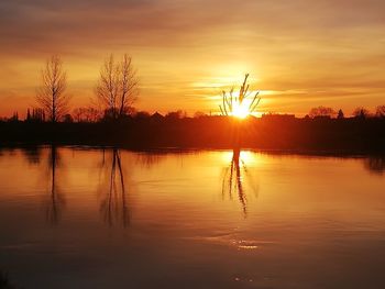 Scenic view of lake against romantic sky at sunset