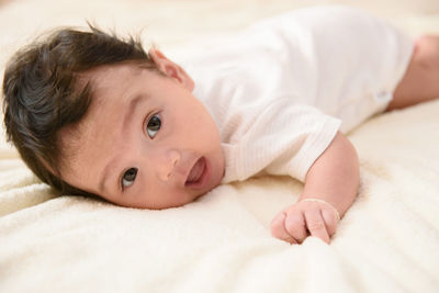 A cute little asian baby lies on the stomach with copy space