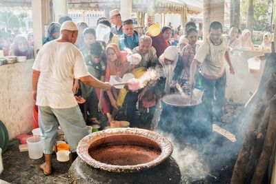 Group of people working at market stall