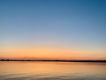 Scenic view of sea against clear sky during sunset