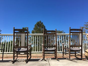 Chairs on beach against clear blue sky