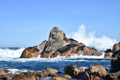 Rock formation on beach against sky