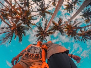 Low section of people on palm tree against plants