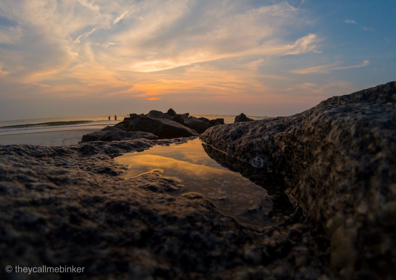 ROCKS ON SHORE AGAINST SKY DURING SUNSET