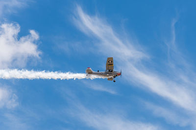 Low angle view of airplane flying against sky