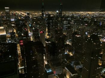 Aerial view of illuminated buildings in city at night