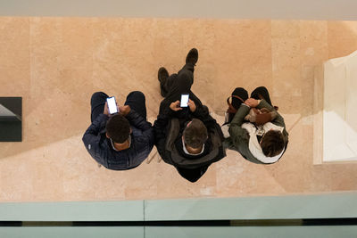 High angle view of people sitting on wall