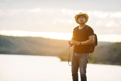 Portrait of smiling man standing against sky