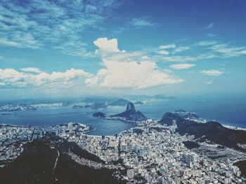 Aerial view of sea and mountains against sky