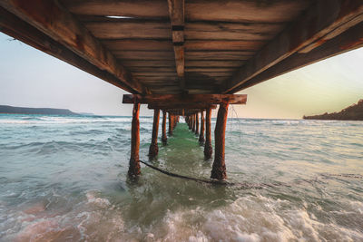 Interior of pier over sea against sky