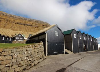 Houses by building against sky