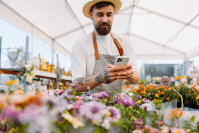 Man gardener working wit mobile phone. e-commerce, online order concept.