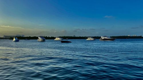 Boats in sea against blue sky