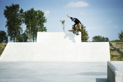 Young man performing stunts on skateboard