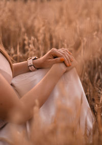 Low section of woman sitting on field