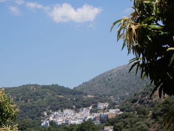 Townscape by mountains against sky