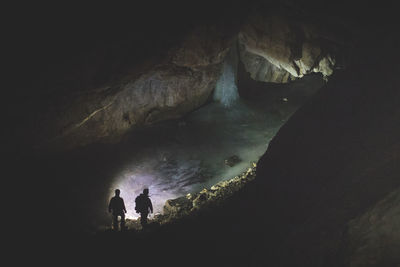Low angle view of silhouette people standing in cave
