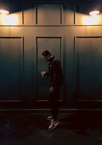 Full length of young man standing against wall