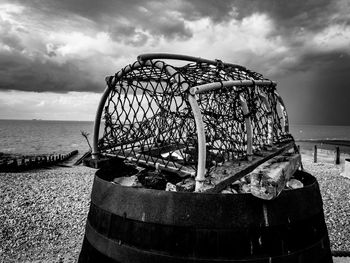 Lobster basket on beach against sky