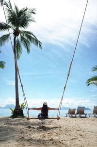 Rear view of people sitting on beach