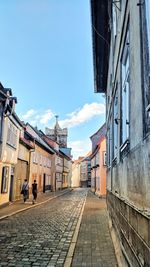 Street amidst buildings in town against sky