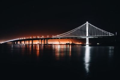 View of bridge over river at night
