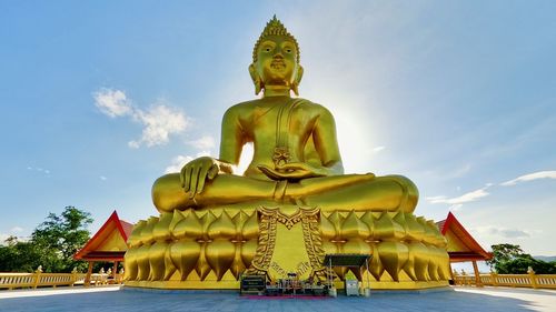 Statue against temple against sky