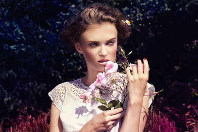 Portrait of young woman holding flower