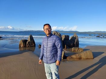 Portrait of young man standing at beach