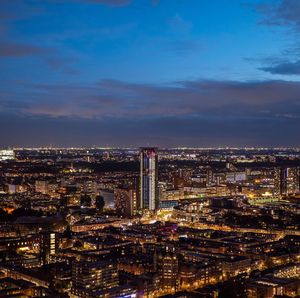 High angle view of city lit up against sky