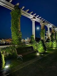 Illuminated bridge over river against sky at night